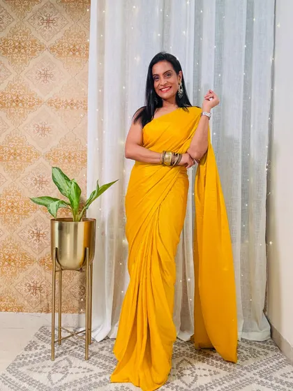 A simple and elegant solid yellow pre-stitched saree. This is a versatile piece that can be dressed up with heavy jewelry or kept simple for a minimal look.