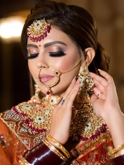 This bride's eye makeup features a beautiful blend of gold glitter and dark brown, creating a dramatic and festive look.