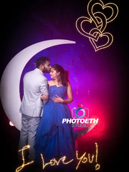 A whimsical and romantic pre-wedding portrait using a large moon prop and neon light graphics. The vibrant colors create a fun and dreamy atmosphere.