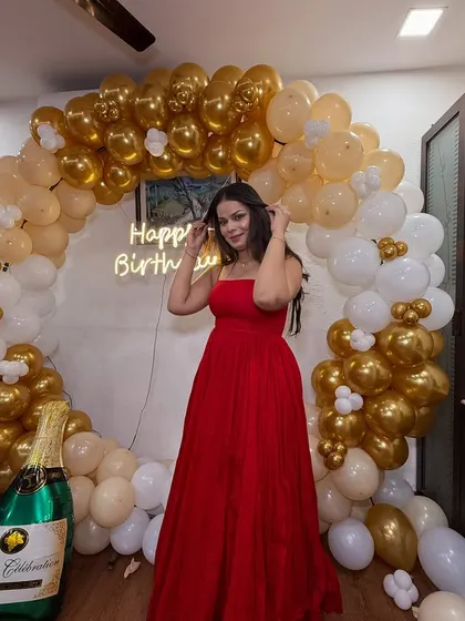 A full-length shot of the birthday girl. The red dress and the glam makeup are a perfect combination for a celebration.