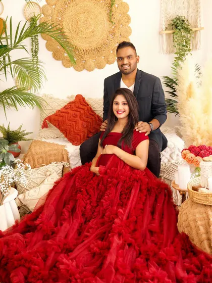 A beautiful portrait of the couple in our cozy boho studio. The rich red of her gown adds a vibrant touch to the warm, earthy tones of the set.