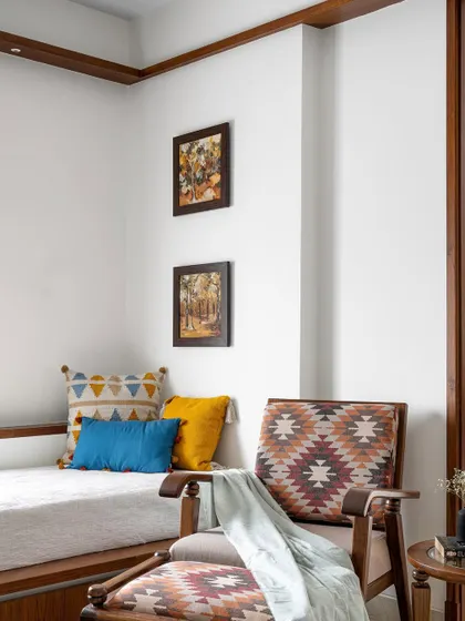 A cozy corner in the 'Gulmohar' family space, featuring a platform seat and an armchair with vibrant, patterned upholstery.
