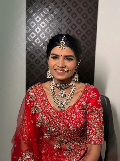 My beautiful bride Nayna, looking radiant and happy. We chose a classic look with a red lehenga, complemented by stunning emerald and pearl jewellery.