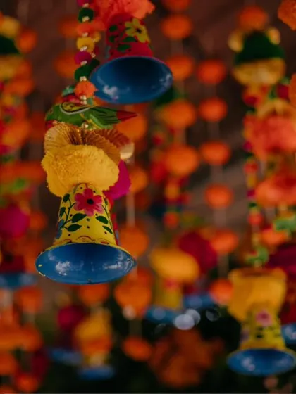Colorful Jaipuri puppets and tassels hang from the ceiling, adding a playful and traditional Rajasthani element to the Haldi decor.