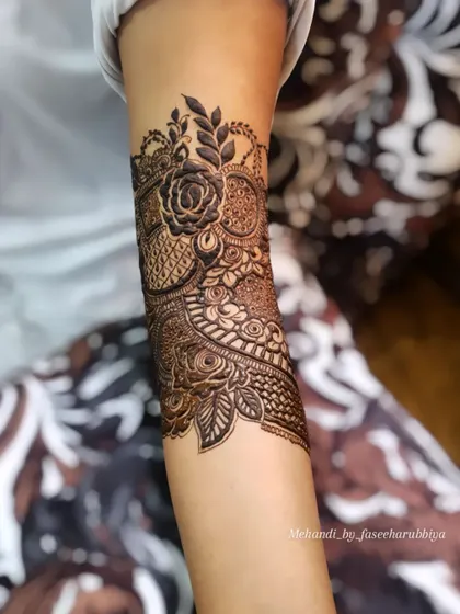 The start of a bridal design, showing the first few floral motifs being laid down on the arm.