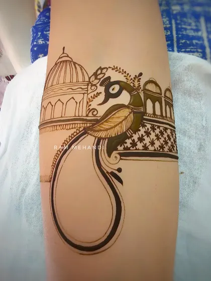 Here you can see the process of outlining a peacock and palace arm band. I start with the basic shapes before filling in the intricate details.