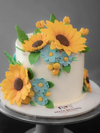 A stunning cake adorned with vibrant, handcrafted sugar sunflowers, bringing a burst of happiness to any celebration.
