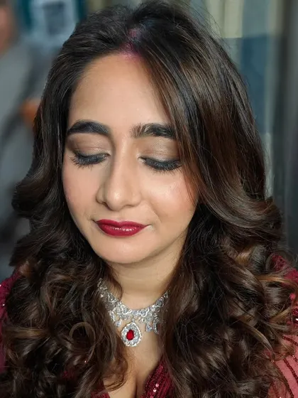 A close-up of the bride's reception makeup. The eyes are softly defined, and the red lip is the perfect statement.