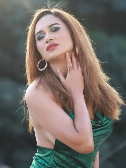 A close-up portrait focusing on the model's makeup and the texture of her hair.