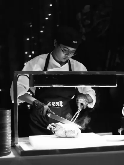 A chef at a live carving station, expertly slicing roasted meat for guests.