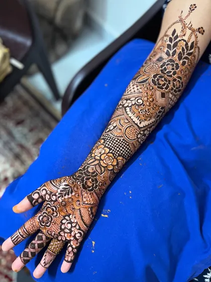 A full arm view of a bridal henna design, combining floral patterns with geometric fillers for a modern and intricate look.