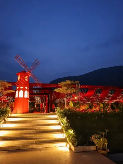 A wide view of a reception designed to impress. The entire venue, set against the mountains, was transformed with dramatic red lighting and a signature windmill feature, creating a truly magical destination wedding experience.