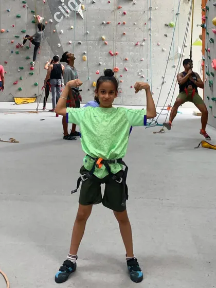 A young climber flexes, feeling strong and accomplished after a great session. We love seeing our climbers build confidence.