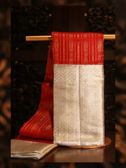 A captivating red Kanjivaram with a white border and gold zari weaving, featuring classic vertical stripes.