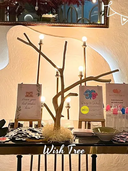 A wish tree station at a baby shower. We set up a table with cards for guests to write their best wishes for the baby, along with other fun games like "guess the number of candies."