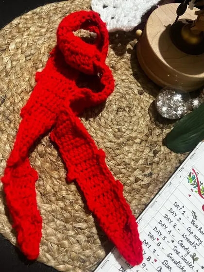 This red crochet bow can be attached to a hair tie, making it a versatile and fun hair accessory.