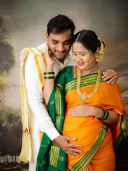 A beautiful traditional portrait of a South Indian couple. Their coordinated ethnic outfits and the loving poses celebrate their culture and their journey to parenthood.