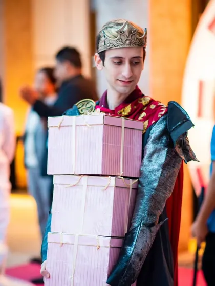 A costumed host delivering gift boxes at a princess-themed birthday party, showing how I can add an element of surprise and theater to your events.