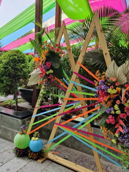 The full view of the 'Colour Pop' photobooth, set against the backdrop of colorful drapes and lush greenery.