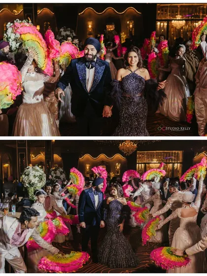 A grand and colorful entry for the couple at their Sangeet, surrounded by dancers with vibrant fans.