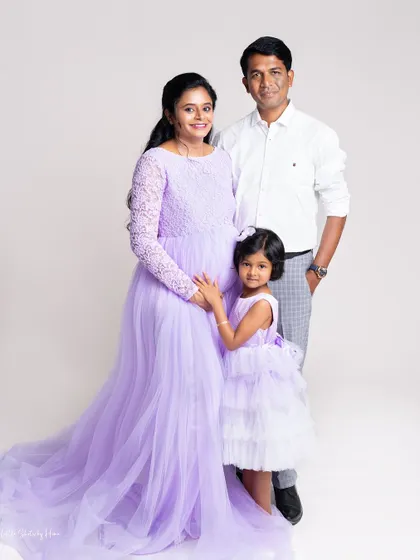 Awaiting the new arrival with so much love. The big sister-to-be is gently holding her mother's baby bump in this beautiful lavender-themed maternity family portrait.