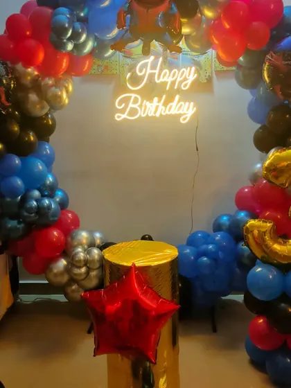A Spiderman-themed circular balloon arch with a neon sign, ideal for a photo backdrop at a superhero party.