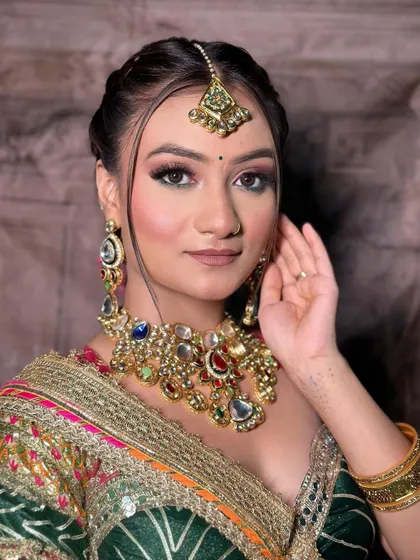 A detailed makeup shot, with the colors of the lehenga complementing the bride's look.