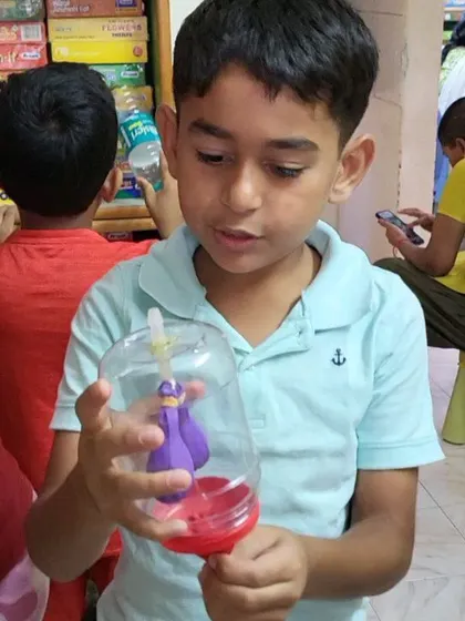 A young student proudly displays the model of human lungs he built. Using a bottle and balloons, we demonstrate how the diaphragm works, making biology interactive and easy to grasp.