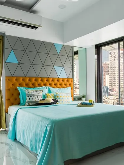 This home is a perfect play of colors. The guest bedroom features a vibrant mix of turquoise and yellow against a geometric grey accent wall, creating a youthful and energetic vibe.