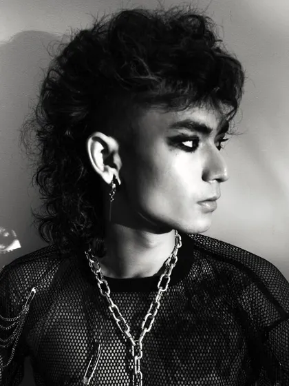 A profile headshot from a punk-themed shoot. This angle highlights the model's unique features and the edgy styling.