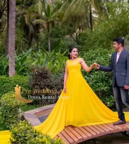 A couple shares a dance on a wooden bridge. The bright yellow trail gown flows beautifully with the woman's movement, creating a joyful and dynamic image.