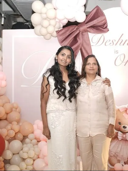 A lovely family portrait in front of the pastel bow-themed backdrop, celebrating a special first birthday.