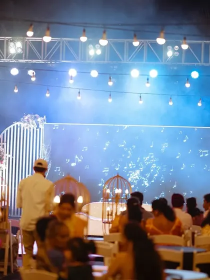 The audience enjoying a performance at an outdoor Sangeet, with a beautifully lit stage.