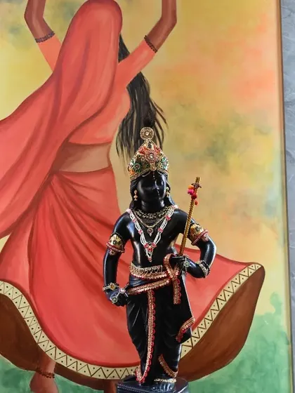 A traditional wall art piece created for a residential project. It features a dancing gopi, inspired by Pichwai art, with a beautiful black stone Krishna idol placed in front, blending painting with sculpture.