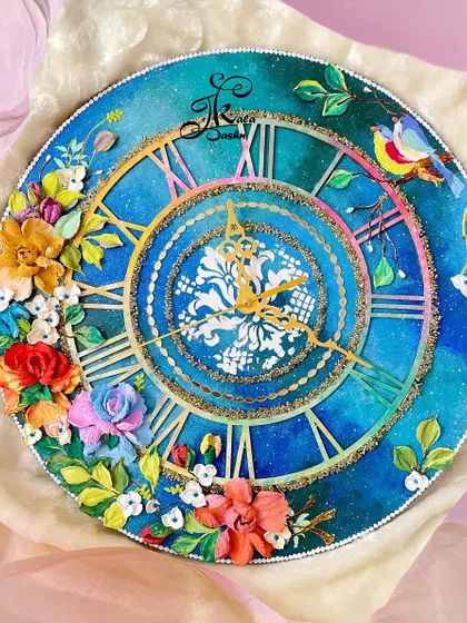 Inspired by a galaxy, this 14-inch wall clock has a deep blue, blended background. I added bright, contrasting flowers, a tiny sculpted bird, and golden accents to create a magical, celestial theme.