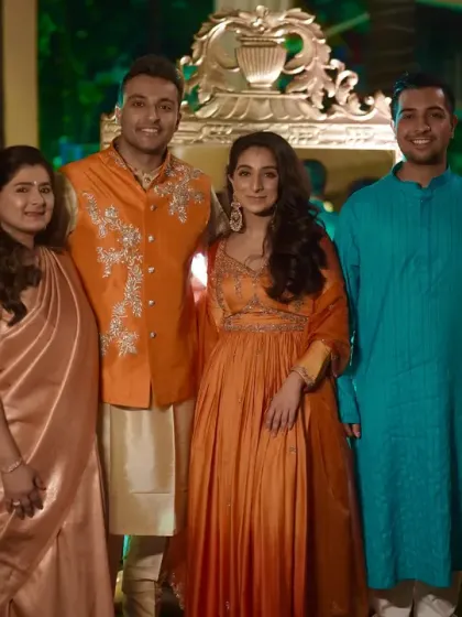 A grand family photo with the couple and their loved ones, all dressed in festive attire.