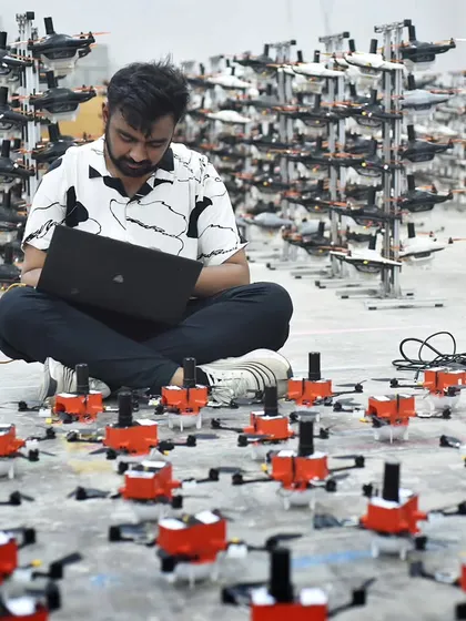 An engineer sits amidst a sea of drones, programming the next aerial ballet. This is where the magic begins, with meticulous coding and testing to ensure every single drone performs its part perfectly.