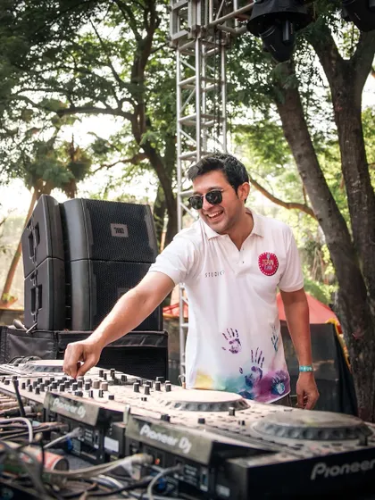 A candid of me at the console during a Holi event, with handprints on my shirt.