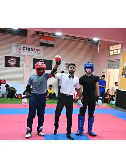 The referee raises the winner's hand, a moment of triumph for our athlete after a hard-fought final at the Mumbai City Championship.