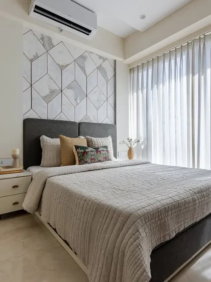 This guest bedroom welcomes visitors in style with a focal point marble bed back made of Statuario marble adorned with golden accents, exuding comfort and refinement.