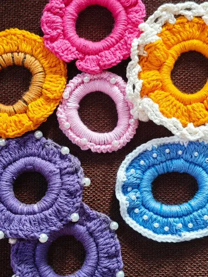 A collection of my crochet scrunchies, showcasing the different styles and colors I offer. From pearls to floral designs, there's something for everyone.