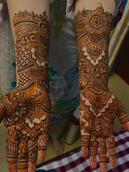A beautiful bridal design with the groom's name, Saqlain, written in Arabic script inside a central circle. This is a popular way to personalize your wedding henna.