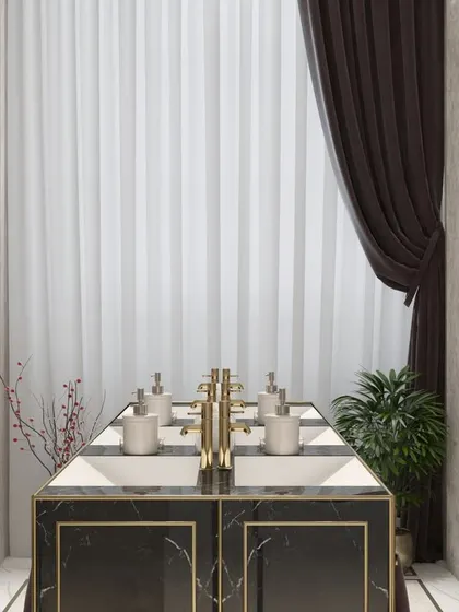 A close-up of the multi-basin vanity in a luxury commercial restroom, with gold-finished taps and black marble countertops.