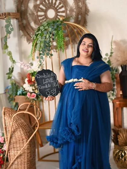 Celebrating twins. This mom-to-be holds a sign that says "Double the love, Double the joy," a perfect way to announce you're expecting two.
