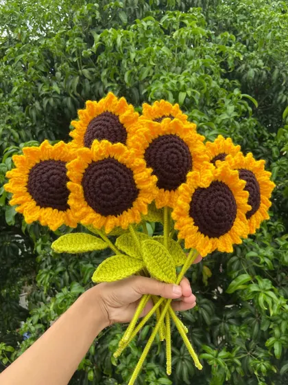 A bouquet of seven bright sunflowers, handmade and ready to brighten someone's day.