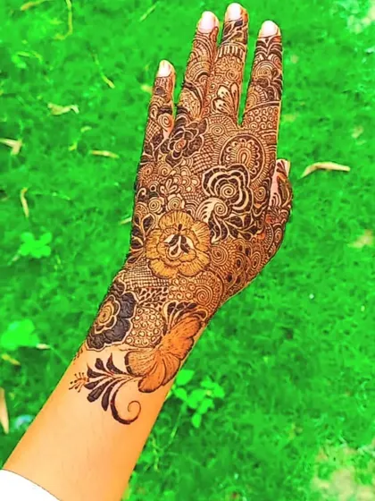 A full hand of henna with a cute butterfly detail at the wrist, adding a touch of whimsy.