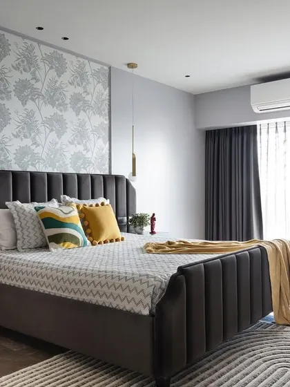 Chic and subtle, this bedroom design pairs a sophisticated grey palette with playful pops of yellow. The channel-tufted headboard adds texture, while the vibrant yellow armchair creates a cheerful and stylish reading nook.