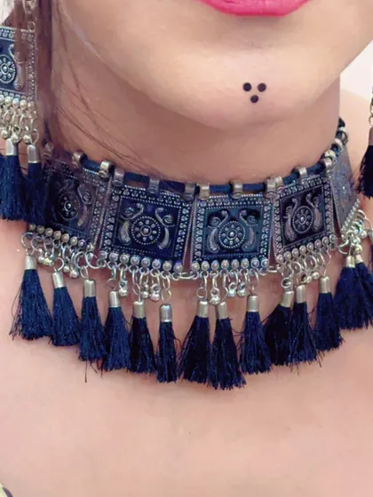 A close-up of a black tassel and oxidized silver choker necklace, a very popular style for Navratri.