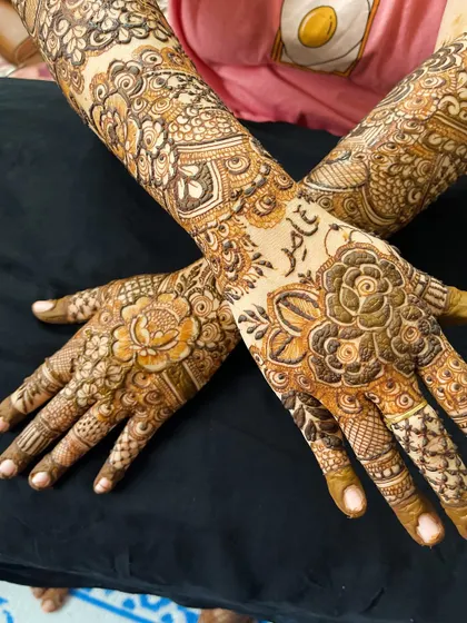 A crossed-hands pose showing the full floral design with the personalized name detail.