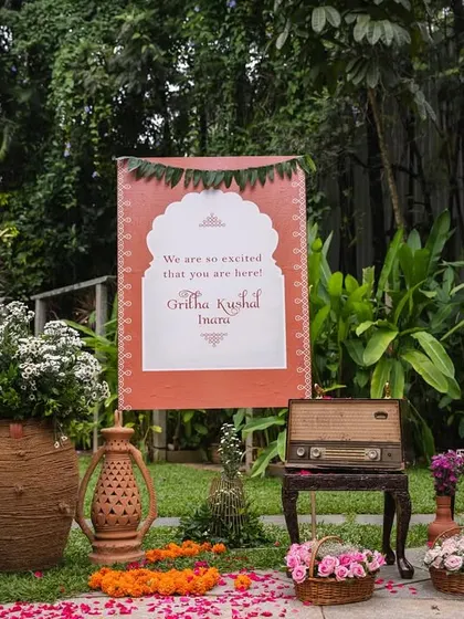 A personalized welcome sign for little Mitharv's naming ceremony. The decor featured rustic elements like a vintage record player and terracotta pots to evoke the charm of a 1990s South Indian village.